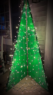 A solid-core door cut in half and flipped to make a Christmas tree, painted bright green, and strung with white lights.