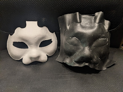 photo of two cat masks, paper pulp on the left and thermoplastic on the right. The thermoplastic mask was made by heating the material and molding it to the paper mask. I expected it to stick but it didn't.