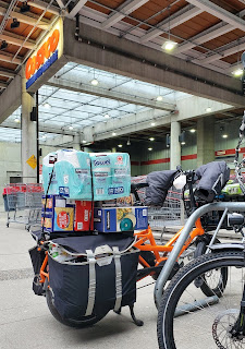 a fully loaded cargo bike parked in front of a Costco