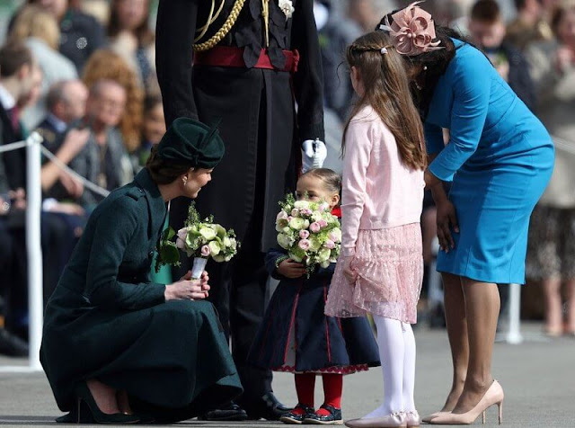 The Duchess wore a new Emilia green coat by Laura Green London. Cartier Shamrock Brooch and diamond and emerald earrings