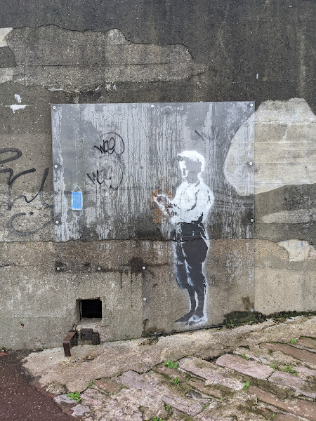 A Banksy artwork on the side of the hill fort