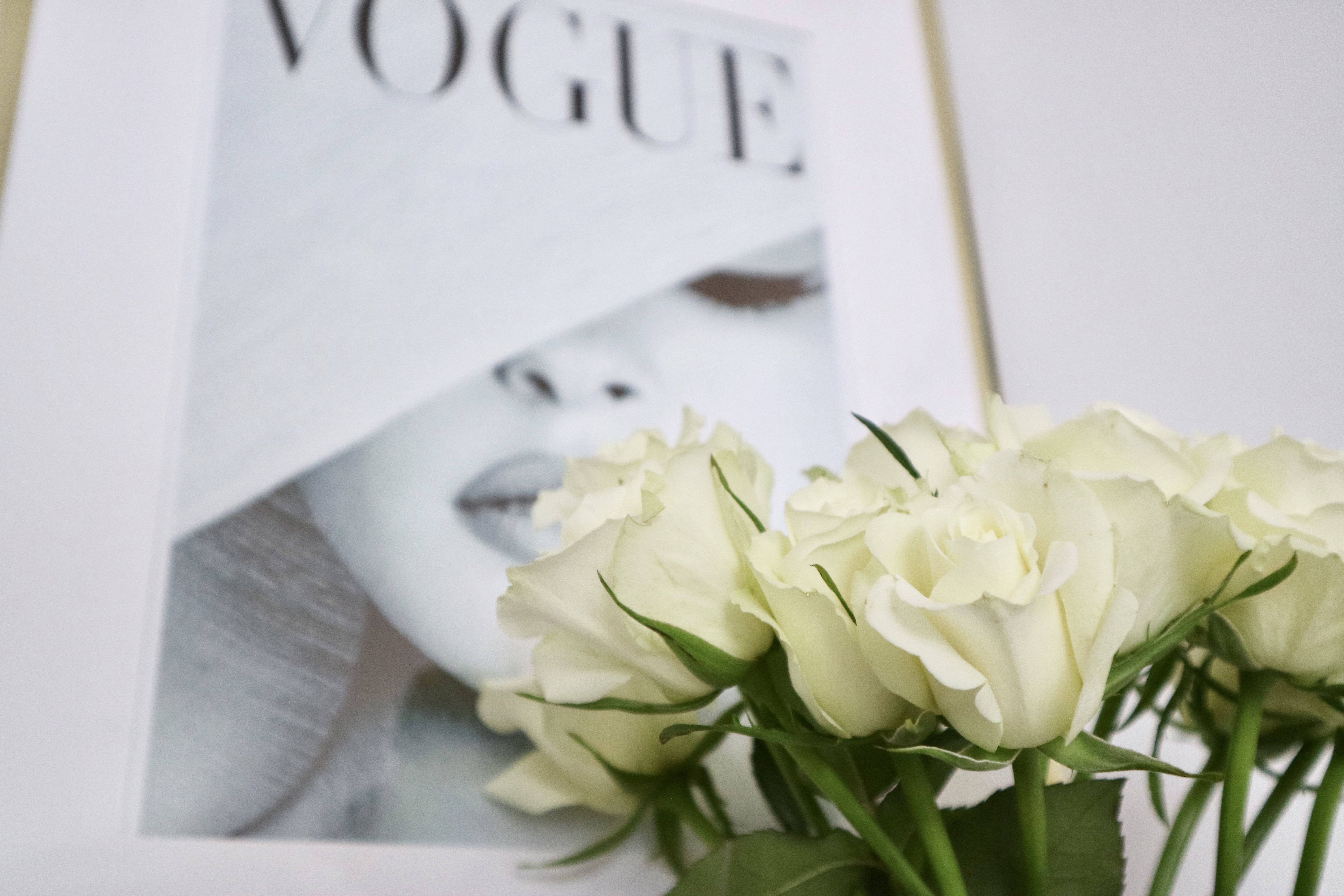 Image of white roses in front of a Vogue magazine cover