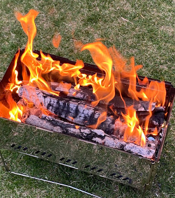 モンベルの焚火台「ファイヤーピット」に薪を入れて燃やしている写真