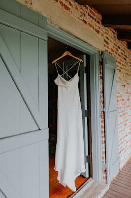 wedding gown hanging on door frame