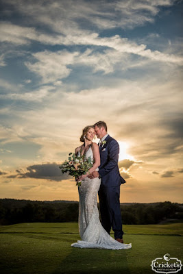 bride and groom cuddling with cloudy sunset
