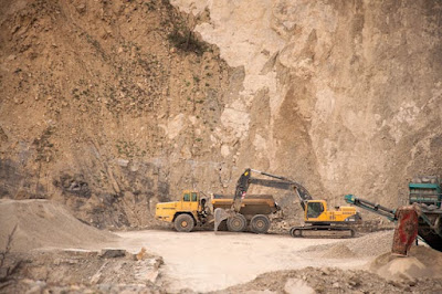 Excavator near industrial machines in lithium mining