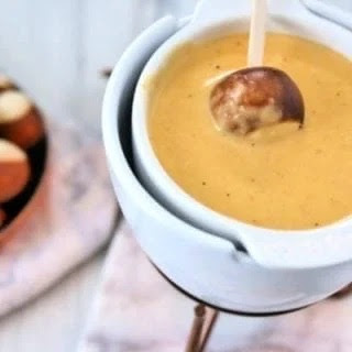 pretzel bite dipped in fondue.