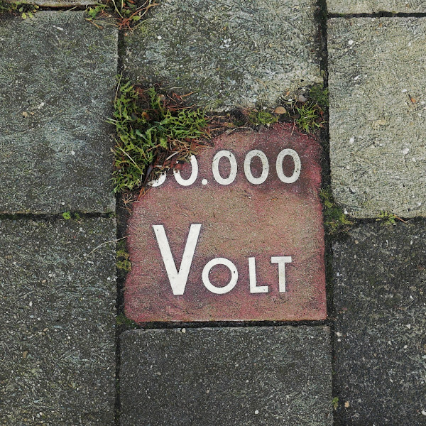 Straattegel met tekst '60.000 Volt'