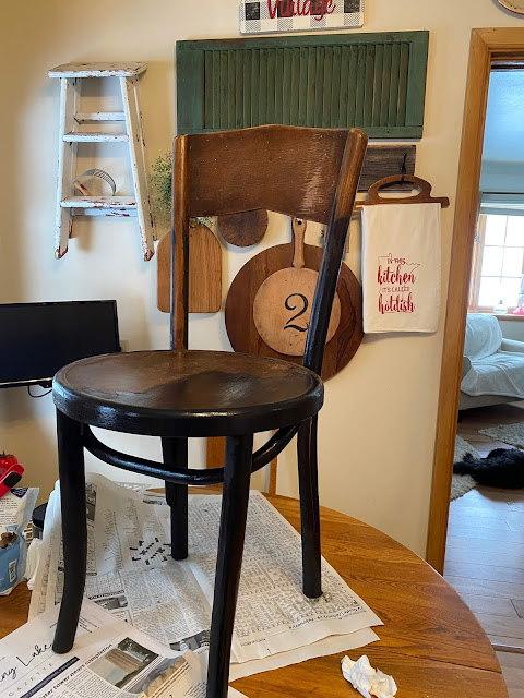 Photo of a bentwood chair being painted with black chalk paint.