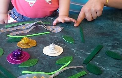 A mom and her daughter are creating flowers with their busy bag.