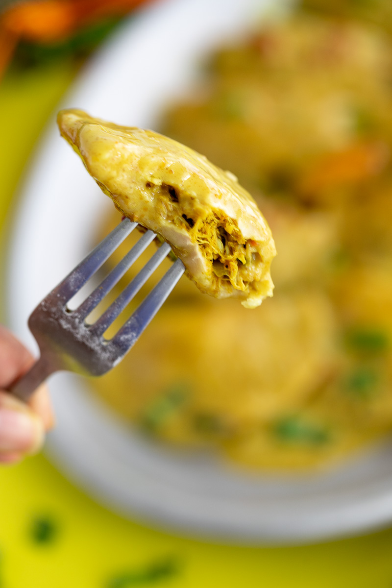 A opened dumpling on a fork showing the curry crab inside.