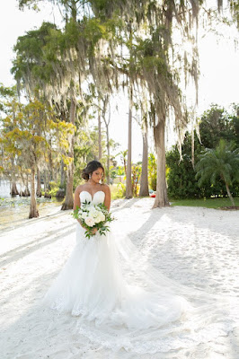 bride holding white flowers on the beach