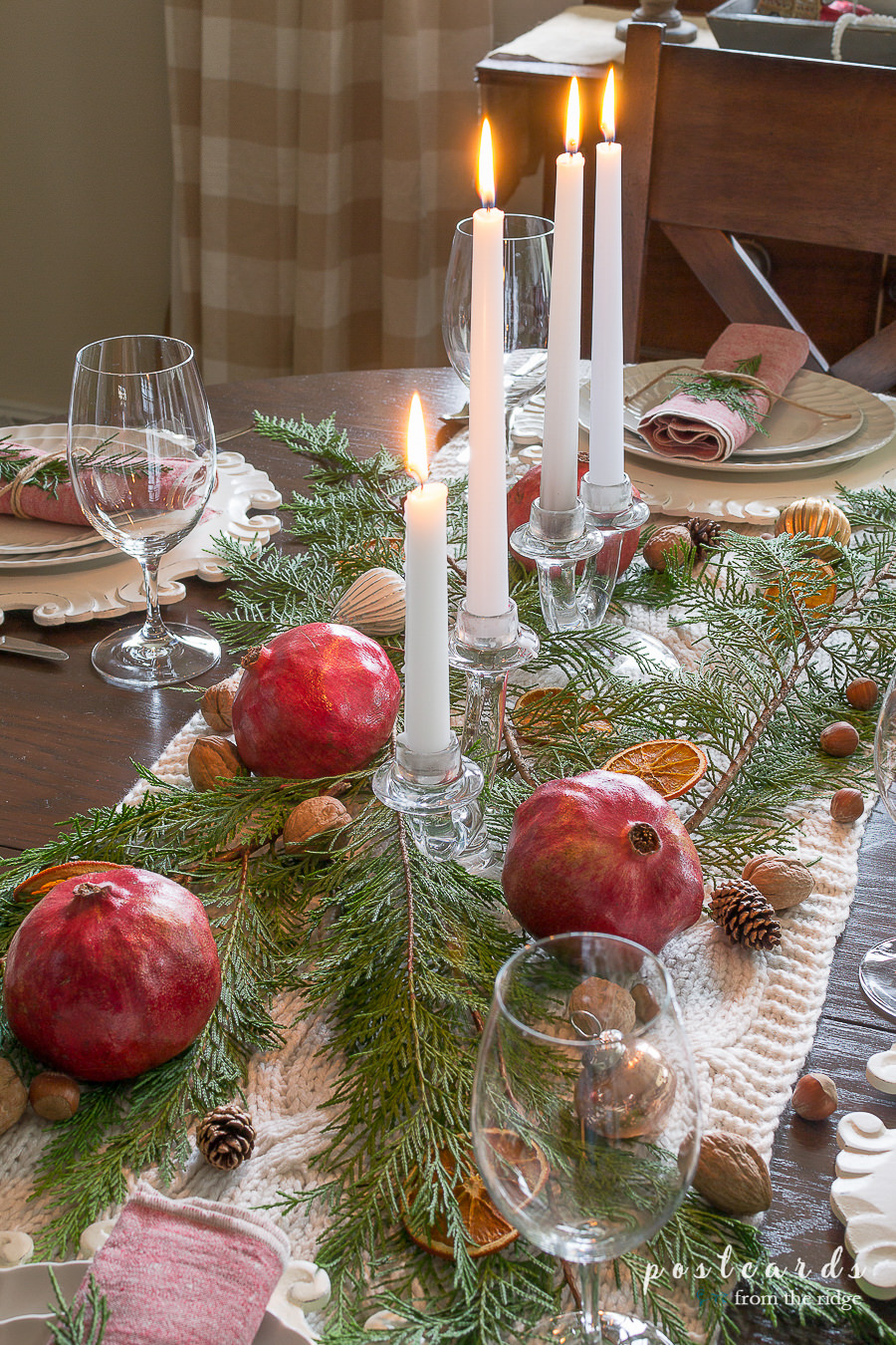 pomegranates and branches with nuts and pine cones on a Christmas table.