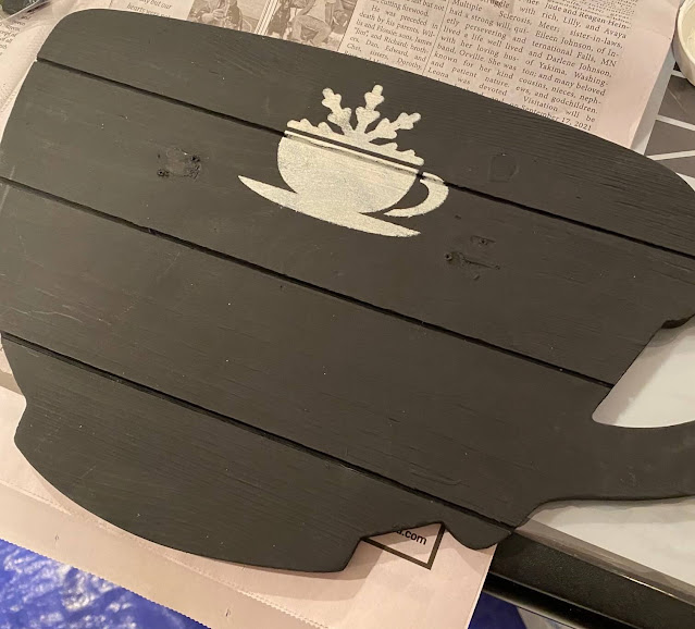 Photo of a MDF/wood veneer cup shape being stenciled with a hot cocoa bar stencil.