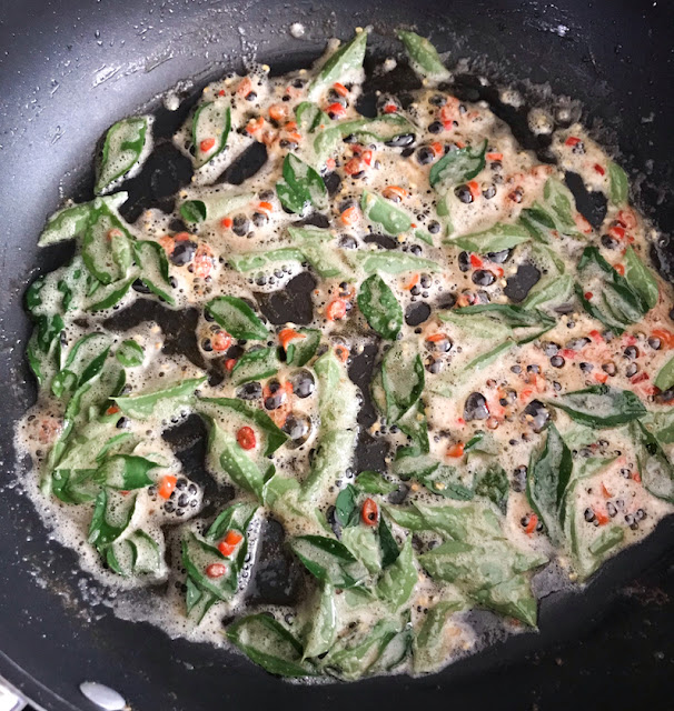 Frying the curry leaves and chili peppers