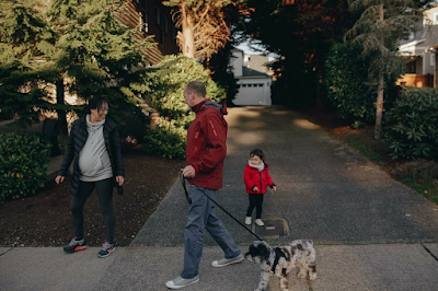 A pregnant woman is going for a walk with her husband, kid, and dog, and they are exploring the best areas in Baltimore for families.