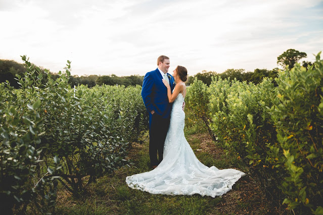 bride and groom standing in green field