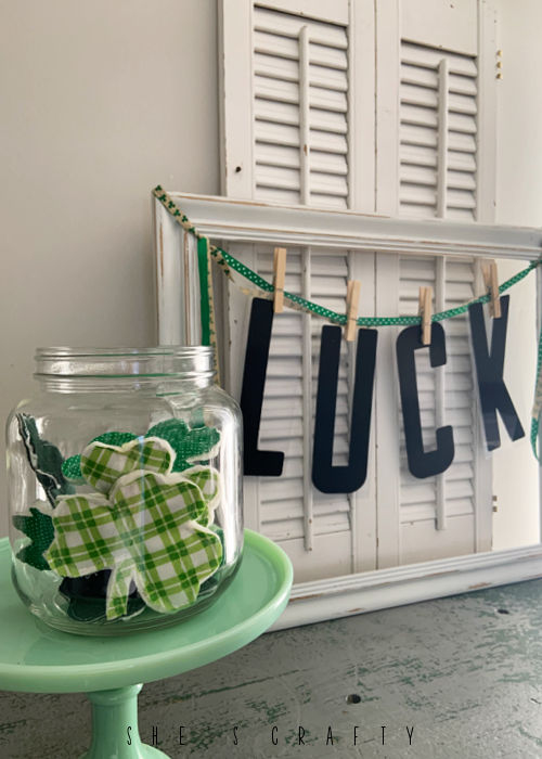 Fabric Shamrocks in a glass jar with LUCK letters in background.