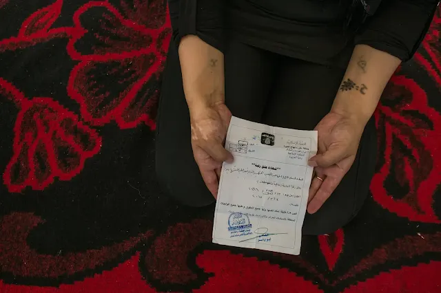 A 25-year-old Yazidi woman showed a “Certificate of Emancipation” given to her by a Libyan who had enslaved her. He explained that he had finished his training as a suicide bomber and was planning to blow himself up, and was therefore setting her free.Credit...Mauricio Lima for The New York Times