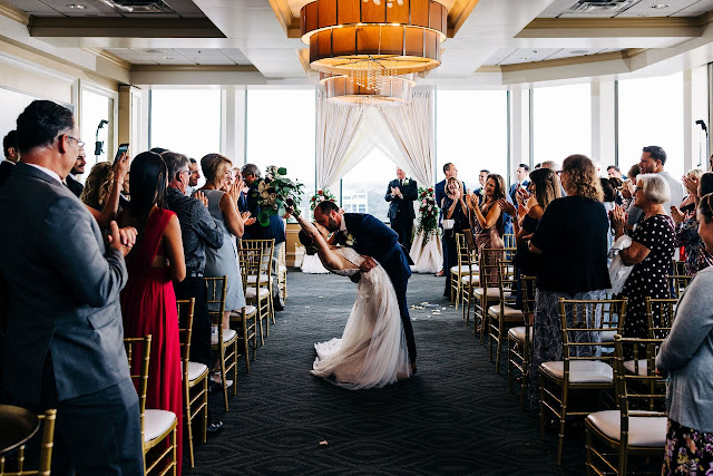 groom kissing bride in aisle