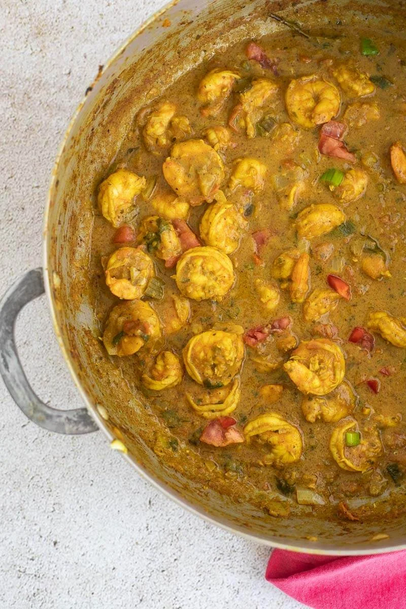 A large metal pot of cooked Trinidad curry shrimp.