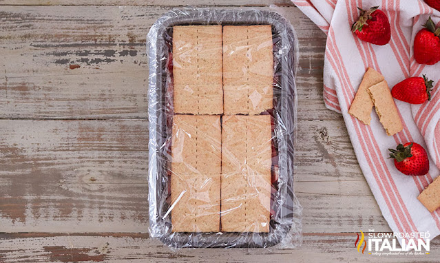 graham crackers in loaf pan lined covered with plastic wrap