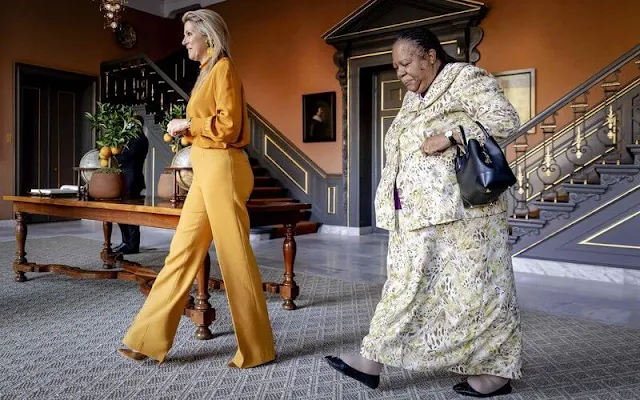 Queen Maxima wore a new orange silk blouse from Natan, and orange trousers by Natan. Fahoma green colour flower earrings