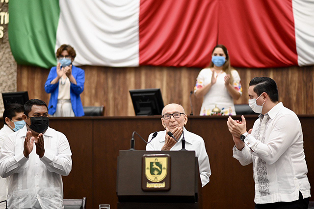 El Dr. Luis David Arjona Canto recibe el reconocimiento Médico del Año en el Estado de Yucatán Mi origen es paupérrimo, mi humildad es de herencia y la disciplina es de mis padres y de mis estudios en el extranjero, asevera  Mérida, Yucatán.- A sus 91 años de edad y acompañado por sus hijos Bricia del Pilar y Ruy Arjona Villicaña, al doctor Luis David Arjona Canto, recibió en el Congreso local  el reconocimiento como el Médico del Año en el Estado de Yucatán, mérito que se entrega por primera vez en el legislativo.  En Sesión Solemne, ante autoridades presentes, el doctor fue ovacionado por casi un minuto, tras recibir el reconocimiento por su destacable labor en el ámbito de la salud y su aportación en el área educativa.  El originario de Dzemul relató algunos de los momentos que lo llevaron a lo que actualmente es, haciendo mención desde su infancia hasta los obstáculos que tuvo enfrentar y reafirmó que, aunque ya no ejerce, conserva al día su preparación en cardiología, por puro gusto y vocación.  “Vocación aceptando lo que dice el diccionario, es algo que Dios te da”, finalizó.  En su turno, la presidenta de la Comisión de Postulación del Reconocimiento del “Médico del Año del Estado de Yucatán”, Abril Ferreyro Rosado, dio lectura a la extensa trayectoria y experiencia que, a lo largo de los años fue captando el doctor Arjona Canto, razones por las cuales, fue electo para recibir el nombramiento.  “Estimado doctor, es usted un digno representante del gremio de la salud en Yucatán, ha sabido unir la práctica con la docencia, ha inculcado los principios de esta noble profesión a quienes han compartido su camino, reconocemos sus ganas de forjar a la juventud y, con esto, puedo afirmar que su nombre y sus actos representan los motivos por los cuales fue usted reconocido con este mérito”, dijo.  Como se infirmó, esta es la primera vez que el Congreso del Estado hace entrega del reconocimiento, en conmemoración del 23 de octubre “Día del Médico” en México, con el cual se enaltece las acciones realizadas en el área de la salud, trayectoria y aportación académica o humanística en el ejercicio de su carrera al servicio de la sociedad yucateca.  Cabe recordar que el pasado 18 de octubre, la comisión aprobó por unanimidad entregar el reconocimiento al Dr. Luis Arjona y, posteriormente, en sesión plenaria del 20 de octubre, se acordó la entrega para este día.  Entre las autoridades, estuvo presente la Secretaria General del Gobierno del Estado, María Fritz Sierra; el representante del Tribunal Superior de Justicia del Estado, Santiago Altamirano Escalante; el Secretario de Salud del Estado, Mauricio Sauri Vivas y el Auditor Superior del Estado, Mario Can Marín, entre otros.  Por último, se acordó la celebración de la siguiente Sesión Ordinaria para el jueves 28 de octubre del presente año, a las 12:30 horas.  Discurso Dr. Luis David Arjona Canto  Hace dos días tuve la agradable visita de la distinguida diputada presidenta de la Mesa Directiva del Congreso del Estado, Ingrid del Pilar Santos Díaz, agradable no sólo por la distinción que me comunicaba, sino que, además de todo, porque su nombre es Pilar como el de mi mamá y de mi hija.  Lo que voy a discursar a continuación no tiene una meta específica y quisiera, si me lo permiten, tomarlo como un encuentro casual del que pueden reírse y analizar sin preocuparse de las responsabilidades que implica emitir una ley.  Mi origen es paupérrimo, mi humildad es de herencia y la disciplina es de mis padres y de mis estudios en el extranjero, la separación de mi familia para comenzar muy temprano mi educación hizo que mi maya no sea perfecta, pero la entiendo bastante y la pronuncio sin fallas. En inglés casi todo lo entiendo y me comunico sin trabas.  Nací en una mesa, en la Hacienda San Eduardo con atención de comadrona, sufrí todas las afecciones ahora evitables con las vacunas y me presentaron en Dzemul, a donde me llevaron en un truck tirado por Rosalío, caballo que aún recuerdo y quien murió hace más de 70 años.  Mi papá era una especie de administrador de Constancia, otra hacienda, en gran medida por ser bilingüe perfecto, igual que mi mamá (bilingüe en ese tiempo quería decir que hablaban maya y español, no inglés y español como se interpreta ahora). Éramos 7 hermanos, 3 de ellas mujeres. Ninguno tuvo ni siquiera sobrepeso porque nunca sobró comida. Ahora solo quedamos 3: 1 en Estados Unidos y otra en Progreso.  En Dzemul solo había hasta 4º grado de primaria, el que repetí 3 veces. Un día le dije a mi papá que quería seguir estudiando, pero no había manera de hacerlo en Mérida por falta de dinero y a donde era difícil viajar. Un día me dijo “¿todavía quieres ir?” Y respondí “sí”. “Vas a ayudar a un carnicero batiendo sangre en el rastro” me dijo. Y así fui a Mérida, batí sangre y terminé el 6º año en la escuela Hidalgo que hoy es un museo, pero ya saben ustedes que el muerto y el arrimado a los 2 días apesta.  Luego, como pude entré a la Secundaria en el Internado para hijos de trabajadores donde nos daban todo, desde comida hasta zapatos y allí supe por primera vez que hay seres humanos malos. Vi a Octavio Paz que era como un asesor que al poco tiempo se fue, según por el calor. Luego todo fue menos duro.  Prepa en el edificio central y Medicina en la Facultad de la Universidad de Yucatán. Aunque vivía sólo y comía donde y como sea y lo que podía, supe que también había gente buena.  Hice mi servicio social en Ticul, donde mi mamá tenía parientes cercanos y al terminar, por incongruencias conceptuales en instituciones en México D.F. no me aceptaron en una de ellas, pero sí me aceptaron afortunadamente en el Doctors Hospital en Washington DC, luego en otro, en Alexandria Hospital, Virginia, donde me nombraron Jefe de residentes a pesar de ser de 2º año.  Con mucho trabajo, la OEA me concedió una beca para estudiar un postgrado en Cardiología y Medicina Interna en la Universidad de Pennsylvania y allí terminé mi postgrado en uno de los sitios más prestigiados de Estados Unidos. Nunca pensé en permanecer en ese país, siempre supe que debía mostrar aquí todo lo bueno que aprendí en Medicina.  Esa ha sido la mejor decisión de mi vida y como dato interesante, muchos años mantuve comunicación con mis compañeros de allá y de otros países, pero desde hace también muchos años ya no pude y la respuesta de sus familiares era que se fueron para siempre.  Conclusión: solo yo sobrevivo con mis casi 91 años y aunque no ejerzo ya, conservo al día mi preparación en Cardiología, por puro gusto y vocación, Vocación aceptando lo que dice en el diccionario, es algo que dios te da. Muchas gracias.  Discurso Dip. Abril Ferreyro Rosado  Como sabemos, nos hemos reunido en esta sesión solemne del Pleno del Congreso para reconocer y premiar los logros de vida de un gran yucateco, me refiero al Doctor Luis David Arjona Canto.  Por tal motivo, me permitiré resaltar algunos detalles de su extensa experiencia curricular personal, académica y laboral.  El Doctor Arjona Canto, es originario del Municipio de Dzemul, Yucatán, en donde inició sus primeros pasos en su formación, surgida de la educación pública en la conocida Escuela Primaria Benito Juárez de su natal tierra.  Al paso de los años, ingresó a la Facultad de Medicina de la Universidad Autónoma de Yucatán, donde se destacó por su entrega y su capacidad.  Posteriormente, realizó un internado rotatorio de pregrado en el Hospital-Escuela O’ Horán, donde con honores recibió el título de Médico Cirujano el 10 de abril de 1959.  Las fronteras del idioma no fueron una limitante para el Doctor Arjona Canto, por el contrario, fueron un aliciente para desarrollar sus aptitudes a nivel internacional; su coraje y amor por su tierra lo impulsó para realizar un internado Rotatorio de Postgrado de Julio de 1959 a junio de 1960 en el Doctors Hospital en Washington D.C.  Asimismo, goza de una gran experiencia, ya que entre los años 1960 y 1968, participó con gran destreza en cursos de especialización en afamadas instituciones académicas de formación médica, tales como el Alexandria Hospital en Alexandria, Virginia; The Graduate Hospital of the University of Pennsylvania en Philadelphia; la Universidad de Luisiana en New Orleans; en la División de Cardiología de la Universidad de Georgetown en Washington y en el Hospital de Massachusetts de la Universidad de Harvard en Boston, Massachusetts.   Es admirable su gran bagaje educacional y de formación como especialista médico, lo cual ha hecho ocupar diversos cargos en el servicio público, de los cuales resaltan el adjunto del Servicio de Cardiología del Hospital-Escuela O’ Horán de 1962 a 1963; la Jefatura del Servicio de Medicina de Mujeres del Hospital-Escuela O’ Horán de 1964 a 1965.  Fue Jefe del Servicio de Cardiología del Centro Anticanceroso de la Asociación Mexicana de la Cruz Roja Delegación Yucatán, desde junio de 1963 hasta 1975; Jefe del Servicio de Cardiología del Hospital-Escuela O’ Horán de la Secretaría de Salud del Estado de Yucatán de 1965 hasta 1986.  No conforme con ello, sentía el deber de compartir sus conocimientos, así como sus experiencias con las nuevas generaciones, por ello, se convirtió en profesor de la Facultad de Medicina de la Universidad Autónoma de Yucatán de 1964 hasta 1997.  Su gran experiencia lo llevó a ser titular en las cátedras de Medicina Interna, Fisiología Cardiovascular, Clínica Cardiovascular y Nosología Cardiovascular.  Además, fue jefe de Clínicas, e incluso antes de la pandemia era Profesor Invitado de la Facultad de Medicina de la UADY, para el Tema de Arritmias en un Curso de Electrocardiografía.  Con tan alto sentido de responsabilidad social, no dudó en forjar instituciones, siendo Socio Fundador del Colegio de Médicos de Yucatán A.C. en 1967 y en dos períodos discontinuos ha sido Presidente de la Sociedad Yucateca de Cardiología, filial de la Sociedad Mexicana de Cardiología.  Su Alma Mater, la Facultad de Medicina de la Universidad Autónoma, le otorgó un reconocimiento por su contribución a la salud de la población del Estado de Yucatán, por sus 50 años de ejercicio profesional, en el marco de la celebración del Día del Médico en el año 2008 y por sus logros en la formación científica y humanística de egresados de dicha facultad en el 2014.  Con esta trayectoria, el Doctor Luis David Arjona Canto, ha dedicado una vida de entrega al servicio público y docente, ello le ha valido muchos reconocimientos, tal como el Reconocimiento de la Sociedad Yucateca de Cardiología, por su valiosa contribución a la Cardiología Yucateca en abril de 1998.  Ha sido homenajeado por su contribución a la Educación Médica Continua por la Asociación Mexicana de Médicos Familiares y Médicos Generales A. C.  Yucatán, en octubre de 2013 y ha sido premiado por su trayectoria en cardiología por la Sociedad Mexicana de Cardiología en el año 2016.  Esta es la vida de una persona dedicada a la profesión médica, y sin duda reúne todos los merecimientos para ser el primer recipiendario al Reconocimiento del Médico del Año que otorga el Congreso del Estado de Yucatán.  Después de leer esta gran historia de vida, Doctor Luis David Arjona Canto, es inevitable no agradecer a todas las médicas y a todos los médicos, que, como Usted, han dado su tiempo, y puesto sus conocimientos para luchar contra las enfermedades, y más desde el surgimiento de la pandemia del Covid19, el cual nos mostró lo frágil que es la vida, y la fortaleza de los profesionales de la salud. El escenario desconocido que hemos atravesado nos ha dado una lección de la valentía y el coraje de cada uno de ellos para interceder ante una nueva enfermedad que ha venido a cambiarnos la vida en muchos aspectos.  Sobrados son los motivos por los cuales el gremio médico y el personal de salud deben ser homenajeados. Nuestro más profundo agradecimiento.  Esta mañana, es por demás especia, pues este Congreso, de manera inédita, impondrá por primera vez el referido Reconocimiento al Médico del Año para este 2021.  Reconocimiento que como sabemos, tiene como objeto distinguir a quienes se han destacado por sus acciones en el área de la salud; por realizar acciones extraordinarias, por su trayectoria o por su aportación académica o humanística en el ejercicio de su profesión al servicio de la sociedad yucateca.  El recipiendario, tal como hemos visto, reúne las características objetivas y subjetivas que lo hacen meritorio a llevar, con alta dignidad, el nombramiento como Médico del Año hecho por esta máxima asamblea local. Por ello, nos encontramos aquí para honrar su labor en las aulas, por fomentar esa chispa por el conocimiento, pero sobre todo, por su amor al prójimo.  La historia de vida del Doctor Luis David Arjona Canto me hace recordar una frase atribuida al filósofo griego Platón, la cual dice:  "Donde quiera que se ama el arte de la medicina, se ama también a la humanidad".  Ser Médico no es una profesión fácil; se debe reunir un perfil racional y analítico, pero, sobre todo, el temple para pelear por la vida ante cualquier circunstancia. Sin duda, el Doctor Arjona Canto, de acuerdo con sus logros personales y académicos, nos permite afirmar que es el mejor ejemplo de cómo saber combinar la vocación y la entrega con la carrera profesional.  Estimado Doctor Luis David Arjona Canto, es usted un digno representante del gremio de la salud en Yucatán. Usted ha sabido unir la práctica con la docencia, pero más todavía, Usted ha inculcado los principios de esta noble profesión a quienes han compartido su camino.   Reconocemos sus ganas por forjar a la juventud en los postulados médicos, esos que tienen raíces desde hace milenios y que en pleno siglo XXI nos muestran el imprescindible valor de los profesionales de la salud. Con estos hechos, puedo afirmar que su nombre y sus actos representan a cabalidad las razones por las que se ha instituido el presente reconocimiento; y hoy que su nombre quedará inscrito en las páginas legislativas, Usted nos premia con su presencia en este Recinto en el que le rendimos un homenaje más que merecido.  Agradezco a todas y a todos los que han participado en la designación e imposición de este Reconocimiento al Médico del Año 2021, como he dicho con antelación, debemos sentirnos orgullosos de compartir con un gran ser humano y excelente profesional de la salud como lo es el Doctor Luis David Arjona Canto.  Como Presidenta de la Comisión de Postulación De Reconocimiento de “Médico del año del estado de Yucatán” le doy la Bienvenida a esta que, a partir del día de hoy, será su casa y digna estancia de sus logros personales y profesionales que serán siempre un recordatorio en aras de la salud; es Usted un gran humanista, su vida es una lección para todas y todos quienes esta mañana le celebran. No me queda más que felicitarle, a Usted, a su apreciable familia, y a sus muchos alumnos. A nombre de las y los diputados de la LXIII Legislatura de este Pleno, le agradecemos sus aportaciones a la práctica médica, es un verdadero honor contar con yucatecos como usted que, sin esperar nada, dan todo por los demás. ¡De todo corazón!, ¡Muchas felicidades!  Es cuánto.