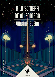 portada del libro de cerbero, fondo azul y una perspectiva con punto de fuga de unas farolas iluminadas en amarillo. Al fondo un hilo de luz anaranjada se cuela de forma vertical por la rendija abierta de una puerta con filigrana entreabierta. Delante de ella hay una persona