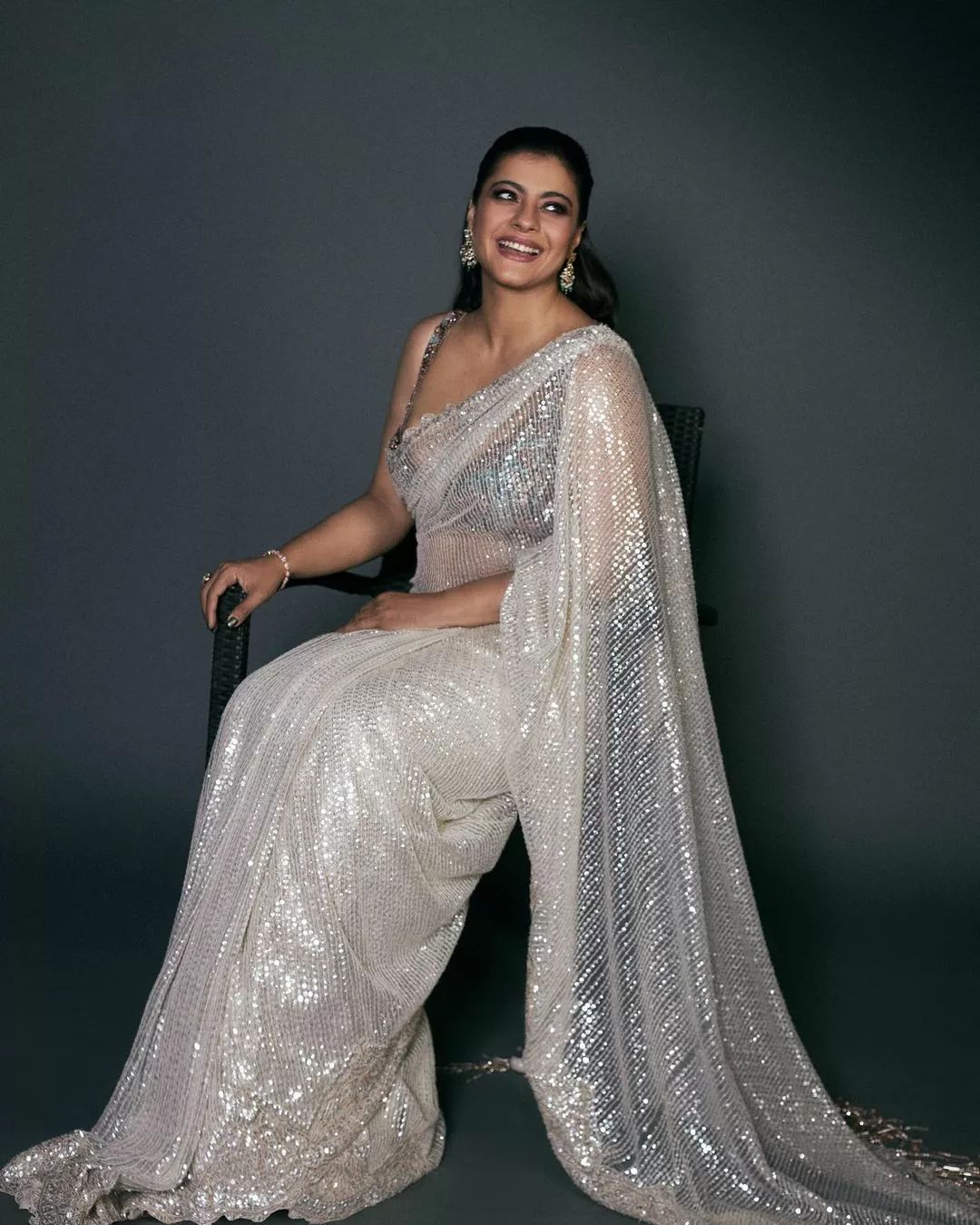 "Bollywood actress Kajol Devgan wearing a sleeveless sequin saree blouse with a plunging neckline."