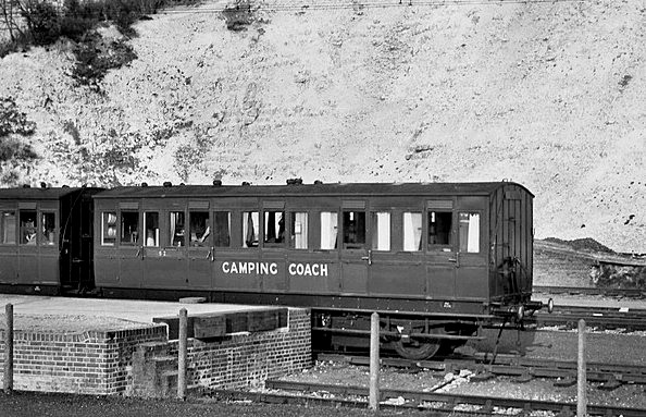 Black and white photo showing an early Southern Railway Camping Coach parked up on a railway station siding