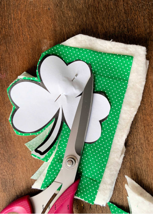 Printed Shamrock Pattern pinned to fabric and cut with scissors.