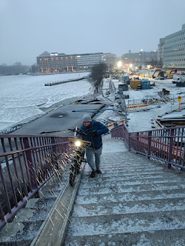 Me pushing a bike up steps in a snow flurry.