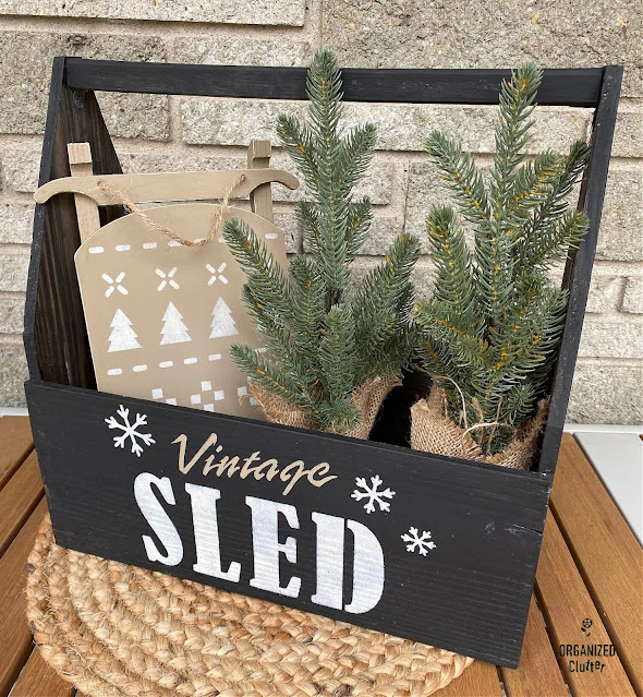 Photo of a thrifted toolbox/tote painted black & stenciled with a Vintage Sled Company Stencil from Old Sign Stencils.