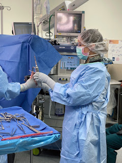 Air Force 2nd Lt. Kristen Bishop is in scrubs assisting an orthopedic surgery.