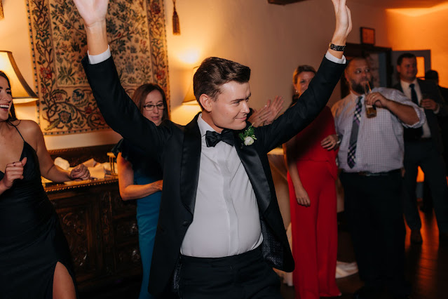 groom dancing with his hands up in the air