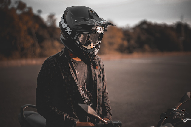 Hombre con casco sobre una moto.