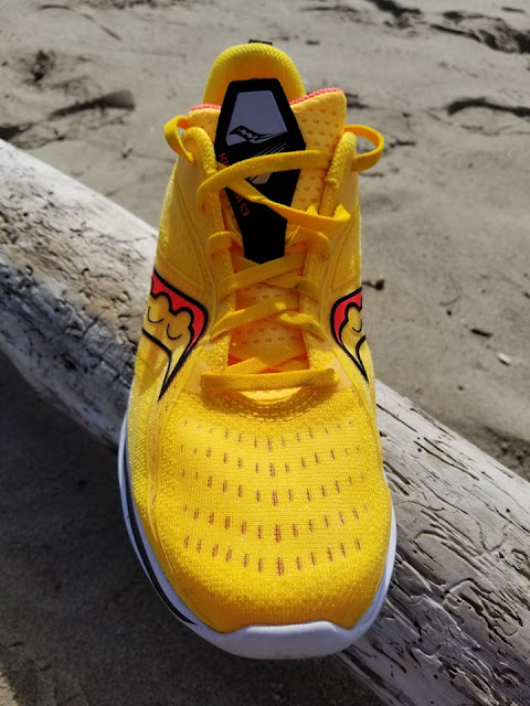 Saucony Kinvara 13, yellow with red logo, on a rock. upper