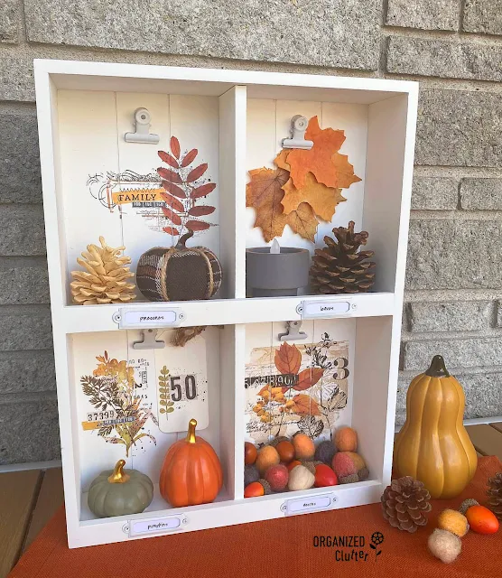Photo of an upcycled thrifted shadowbox decorated with decor transfers and filled with fall mini decor.