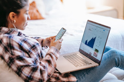 A woman researching the housing market on her laptop and phone