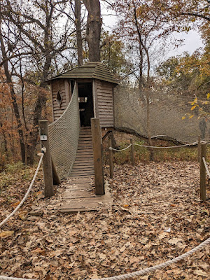 a wooden ramp leads to a treehouse at the Treetop Village inside Arbor Day Farm's Tree Adventure