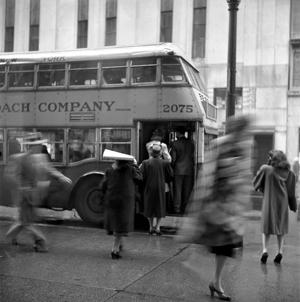 black and white photograph of blurred woman in motion at a bus stop in NYC c. 1946