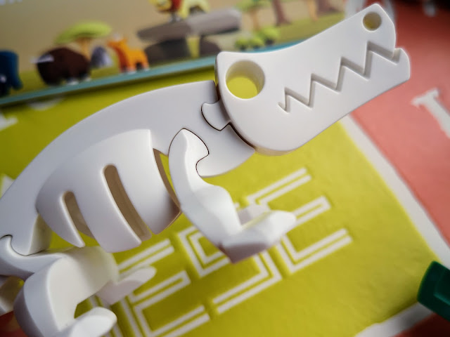 Image of the inside of the imoore 3D Crocodile puzzle. The inside is a plastic skeleton with slide on parts to complete the skeleton. The skeleton is pictured on a brightly coloured background.