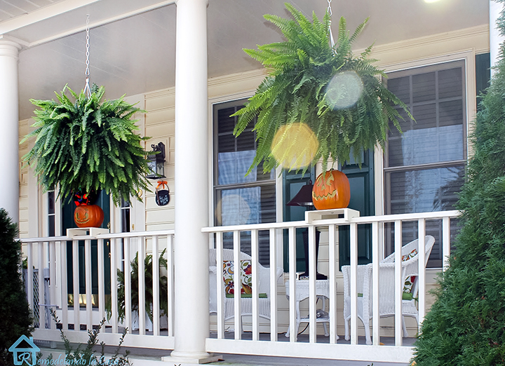 pumpkins sitting on the porch railing