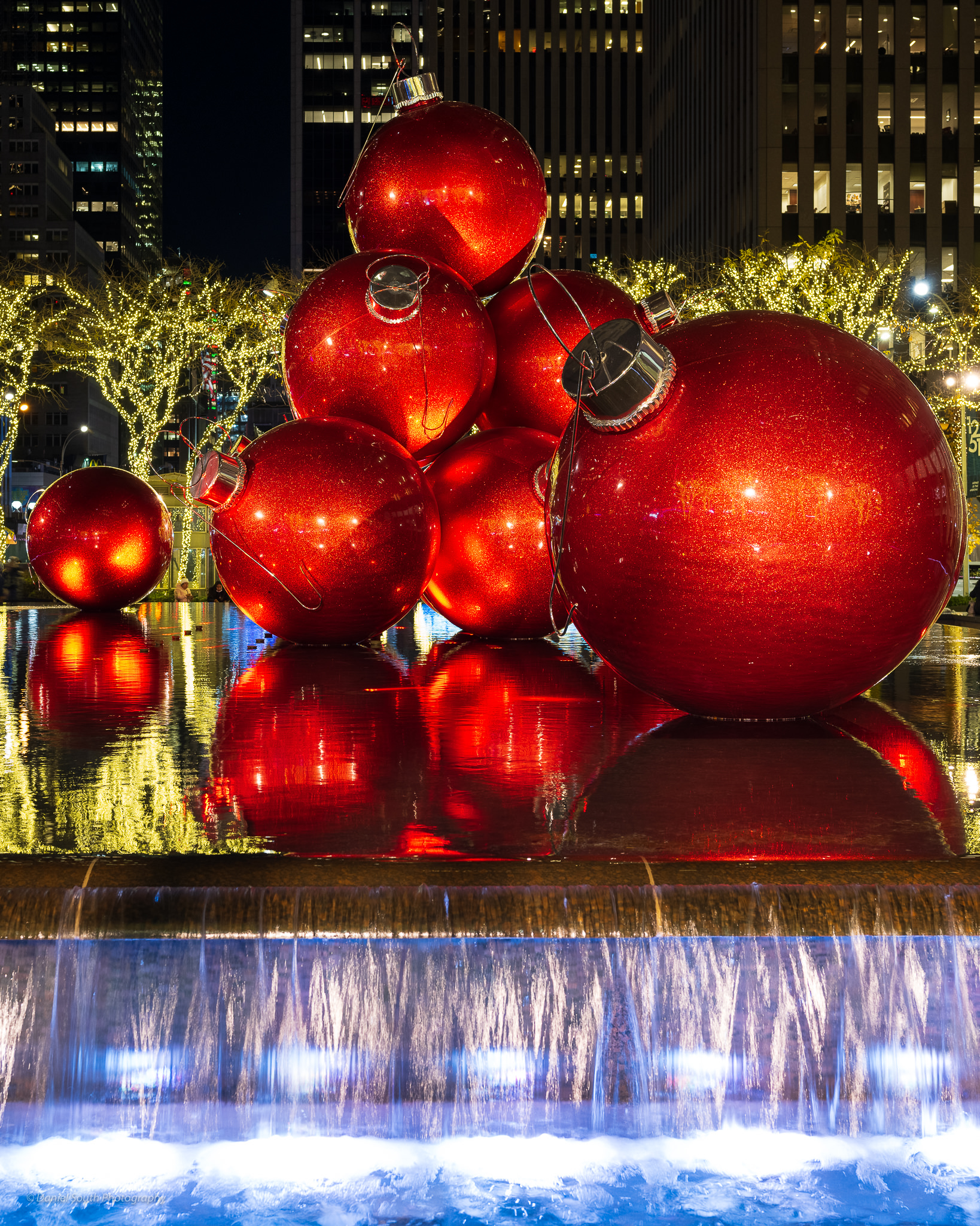 a photo of huge christmas balls in a fountain in new york city