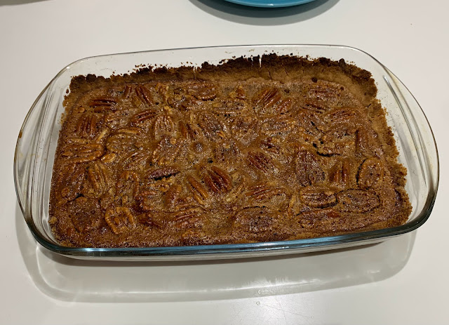 Rectangular glass baking dish containing pecan pie bars