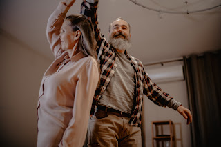 Two elderly people dancing.