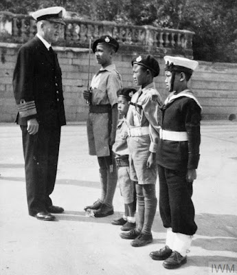 Admiral Sir Bruce Fraser Commander in Chief of the Pacific Fleet with Chinese boys adopted by Royal Marines and Naval Ratings from Duke of York and Euryalus in Hong Kong in February 1946