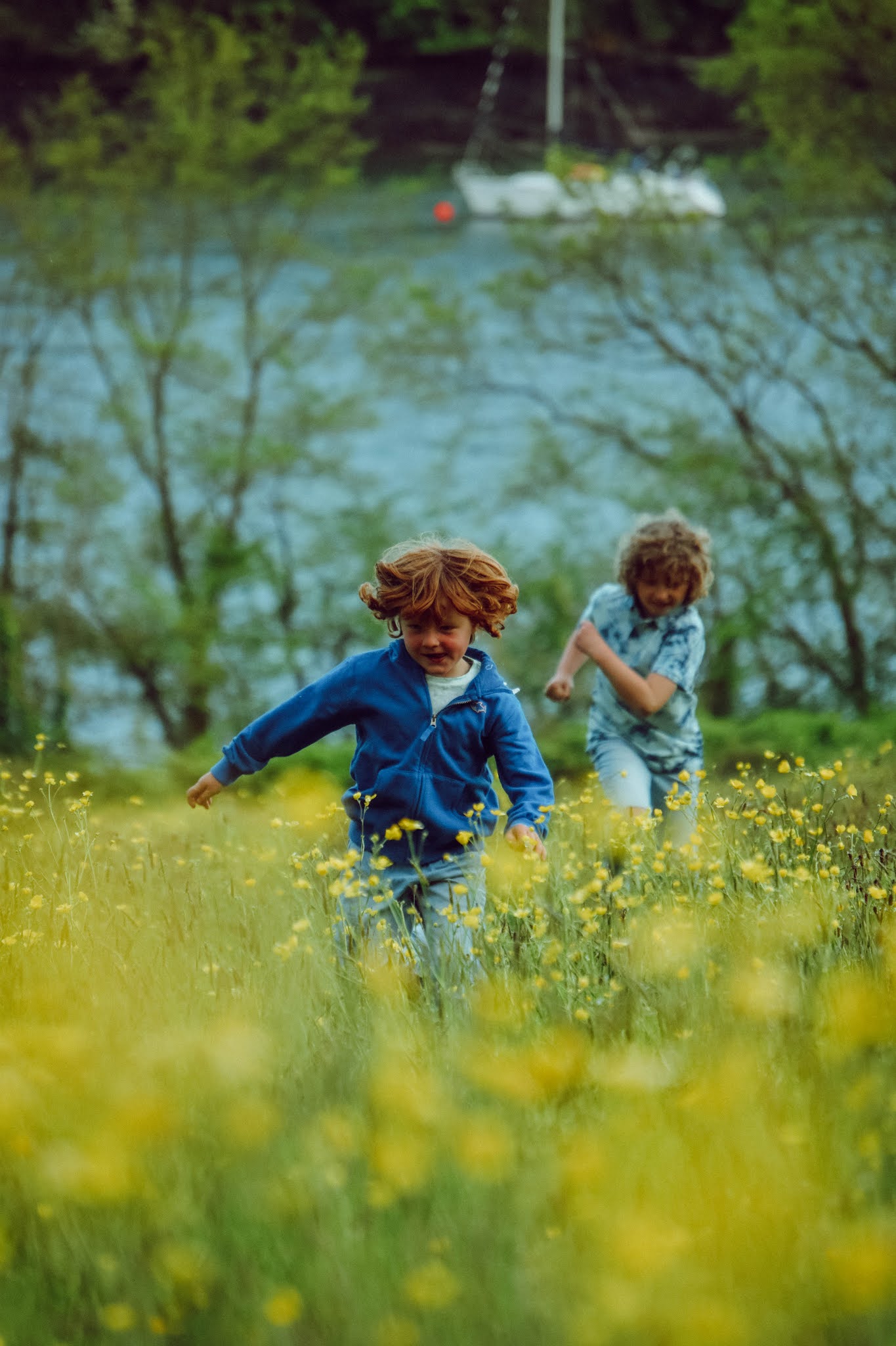 Children running through a buttercup meadow