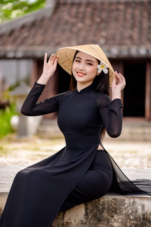 Thiếu nữ ngồi áo dài đen, nón lá
